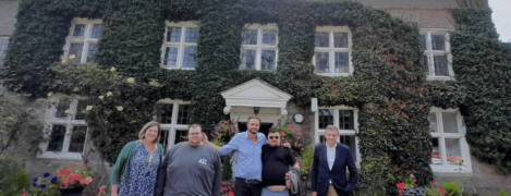 director of operations, Harriet Michael-Phillips, Ben, Tim and Moz with MP David Jones stood outside a beautiful country house with ivy over the walls and a pebble pathway